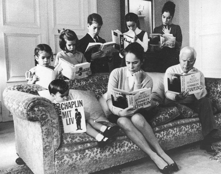 Charlie Chaplin and his family reading his autobiography